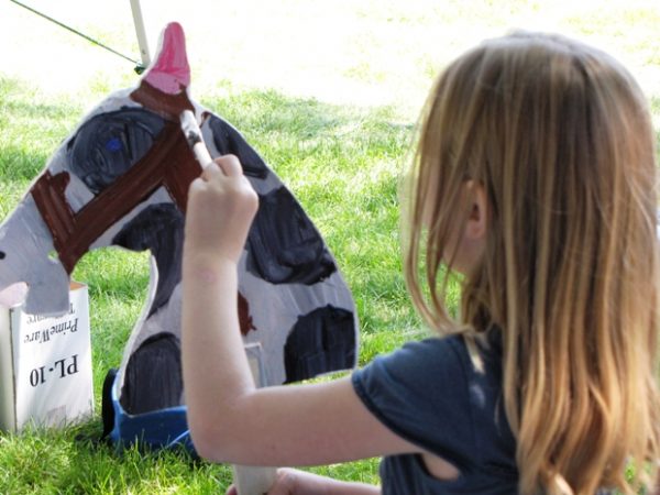 Preparing for the Stick Horse Race- Black & White Stick Horse being decorated by a young girl