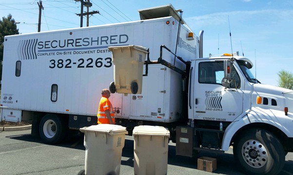 Free Shred Day Is Happening! | Shred truck operator putting shred bin into the truck.