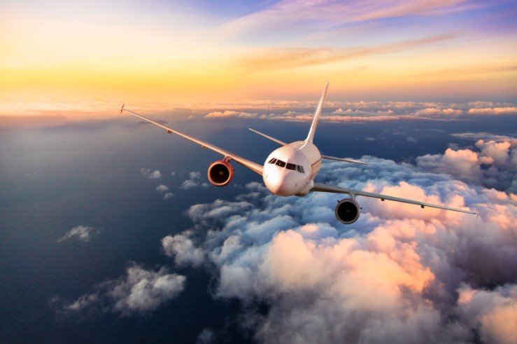 Why now is the time to use airline miles | Airliner Flying Above Clouds at Sunrise