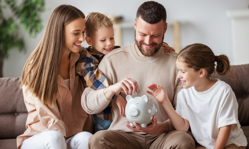 Check-In on 2022 Financial Goals | Family putting coins in a piggy bank