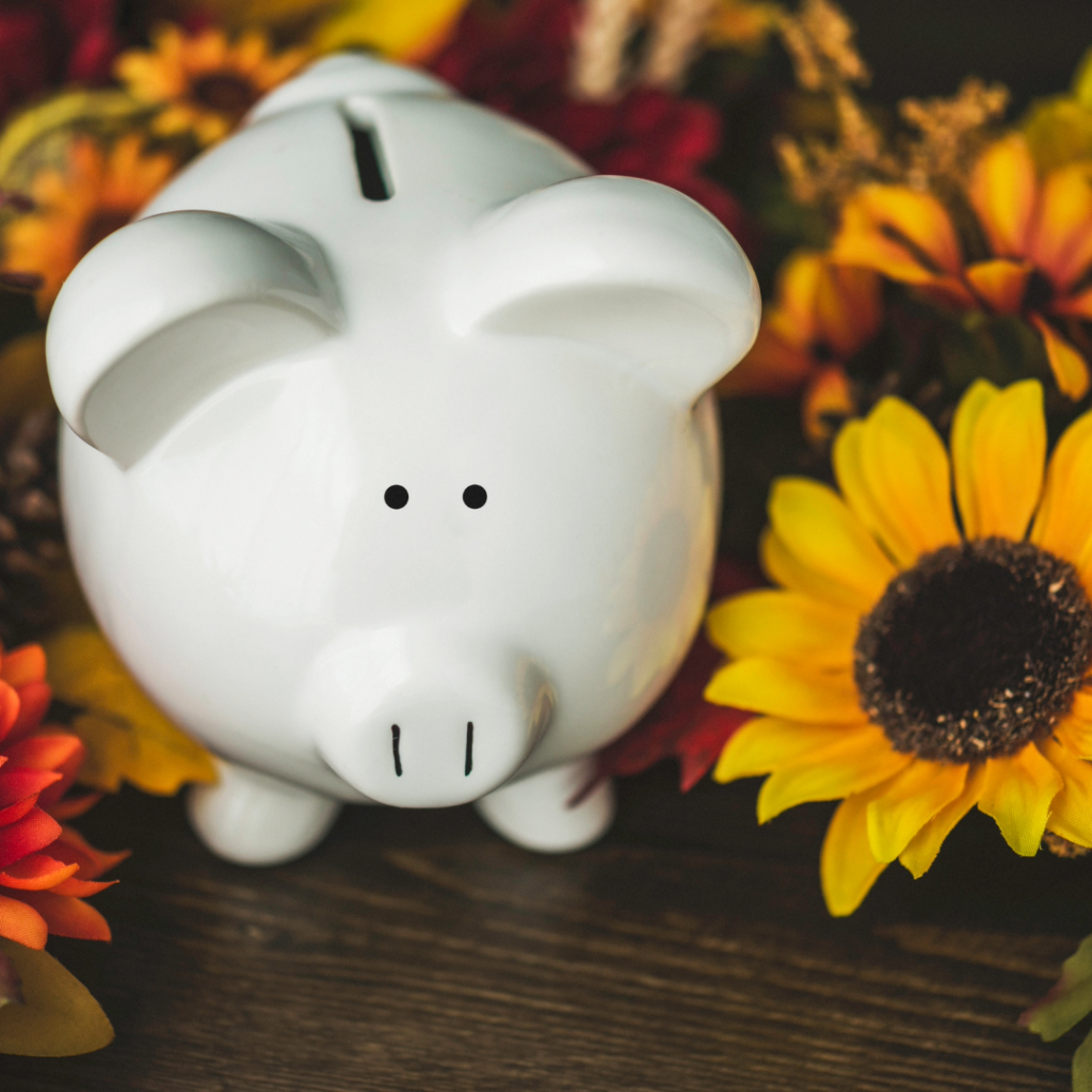 Fall savings concept. Piggy bank with autumnal decorations